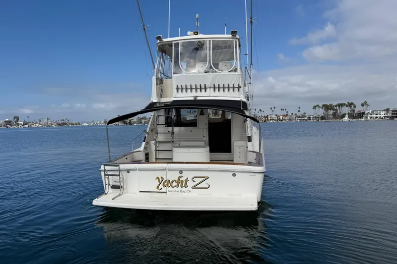 Slide: The Image of 1998 Riviera Convertible yacht on calm water, Alamitos Bay, clear sky background. - 14