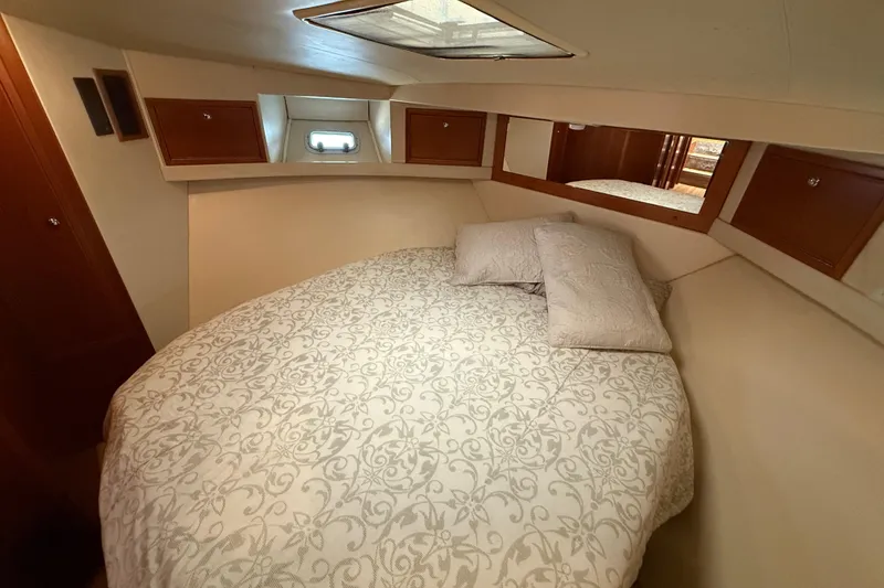 Slide: The Image of 1998 Riviera Convertible boat cabin with cozy bed and elegant wood accents. - 27
