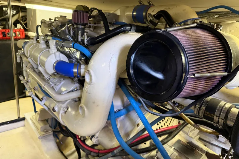 Slide: The Image of 1998 Riviera Convertible engine with blue hoses and air filter in a boat's engine room. - 31