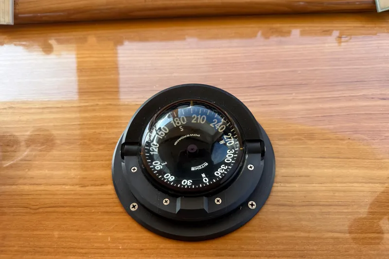 Slide: The Image of Compass on 1998 Riviera Convertible's wooden dashboard, displaying navigational directions. - 39