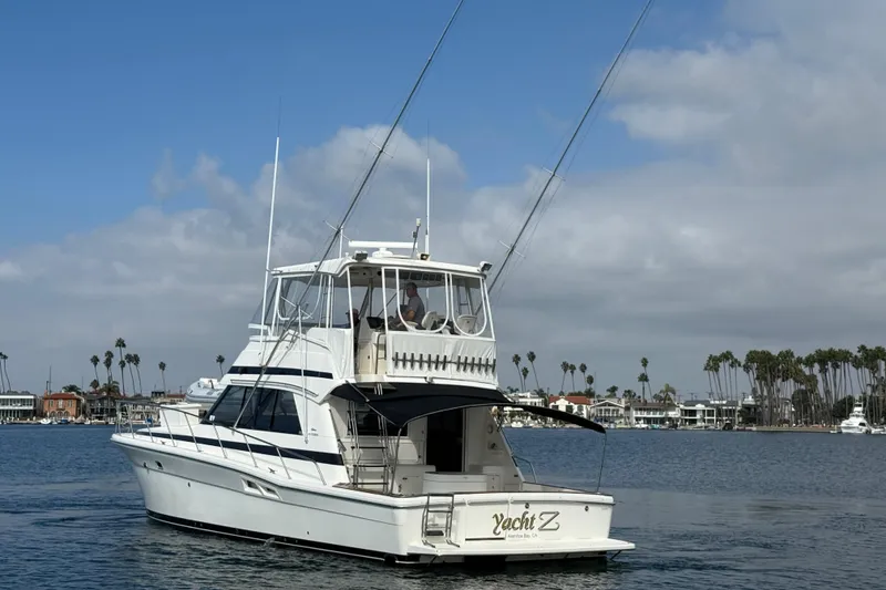 Slide: The Image of 1998 Riviera Convertible yacht cruising on a calm waterway with palm trees in the background. - 4
