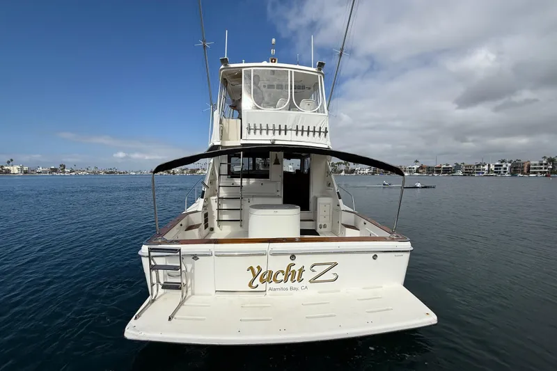 Slide: The Image of 1998 Riviera Convertible yacht docked in Alamitos Bay, CA, under a partly cloudy sky. - 47
