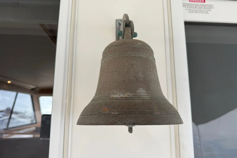 Slide: The Image of Rustic metal bell on a 1998 Riviera Convertible boat interior wall. - 48