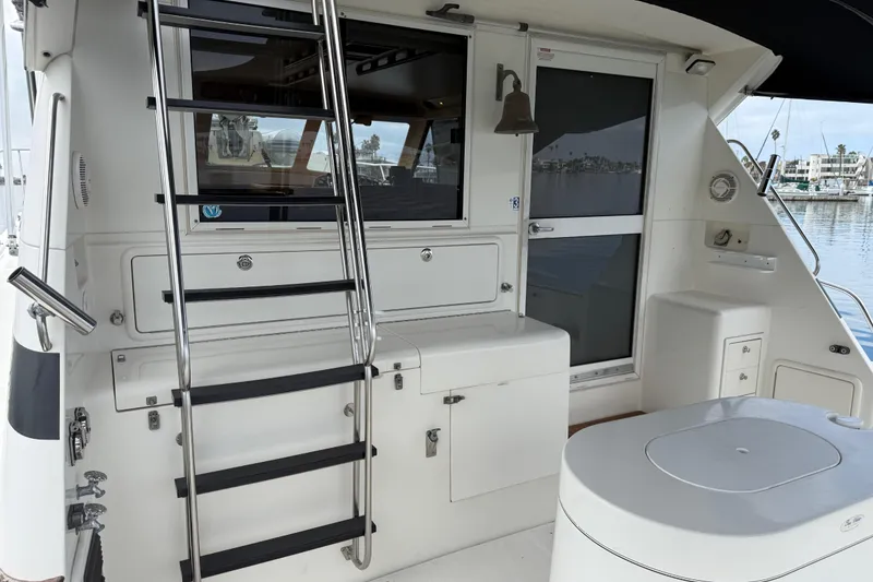 Slide: The Image of 1998 Riviera Convertible yacht interior with ladder, storage, and marina view. - 9