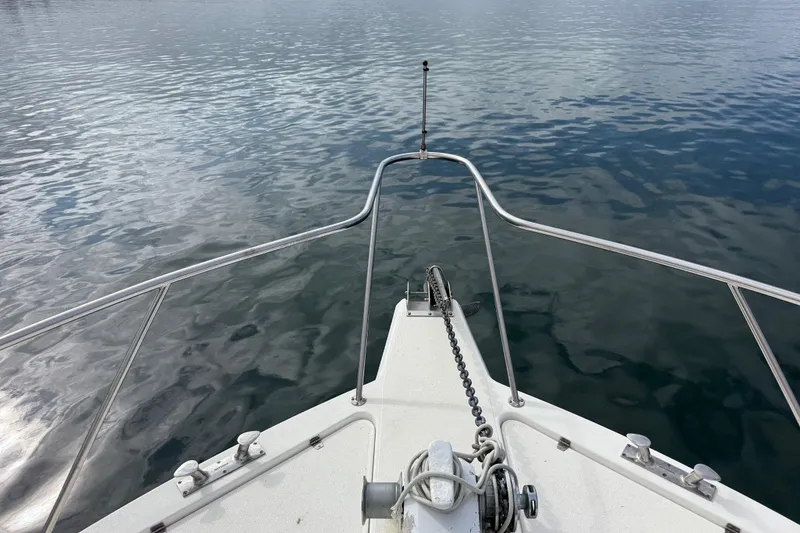 Slide: The Image of Bow of 1998 Riviera Convertible boat on calm water. - 13