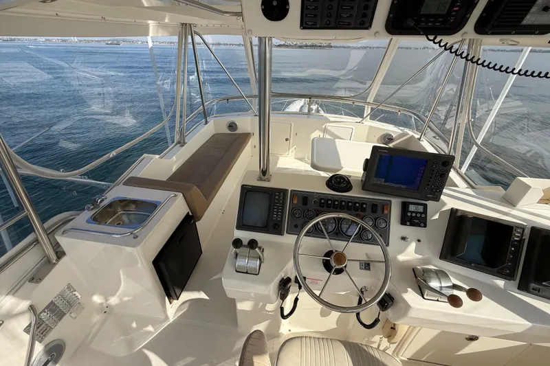 Slide: The Image of 1998 Riviera Convertible boat cockpit with steering wheel, navigation equipment, and ocean view. - 17