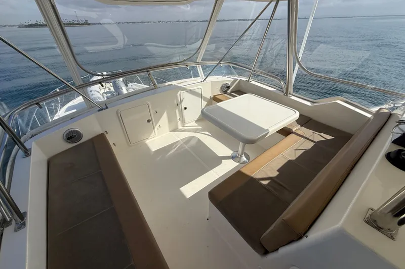 Slide: The Image of 1998 Riviera Convertible boat interior with seating and table, overlooking calm ocean waters. - 18