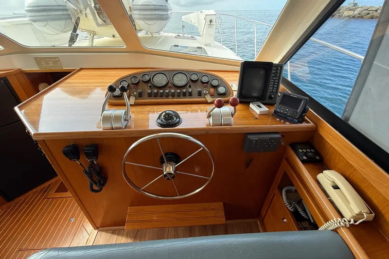 Slide: The Image of 1998 Riviera Convertible yacht helm with steering wheel, controls, and navigation equipment. - 22