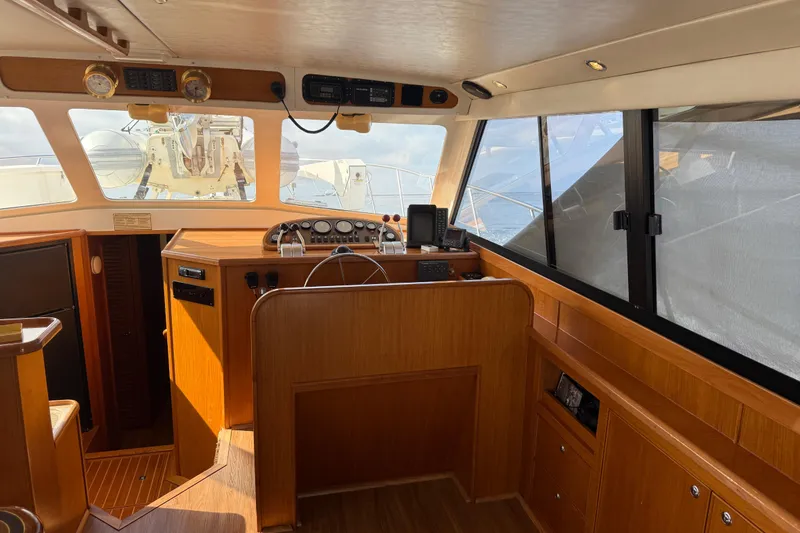 Slide: The Image of 1998 Riviera Convertible yacht interior with wooden helm and navigation equipment. - 23
