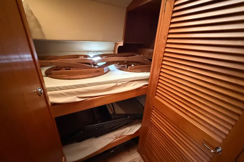 Slide: The Image of 1998 Riviera Convertible interior with wooden bunk beds and storage space. - 25