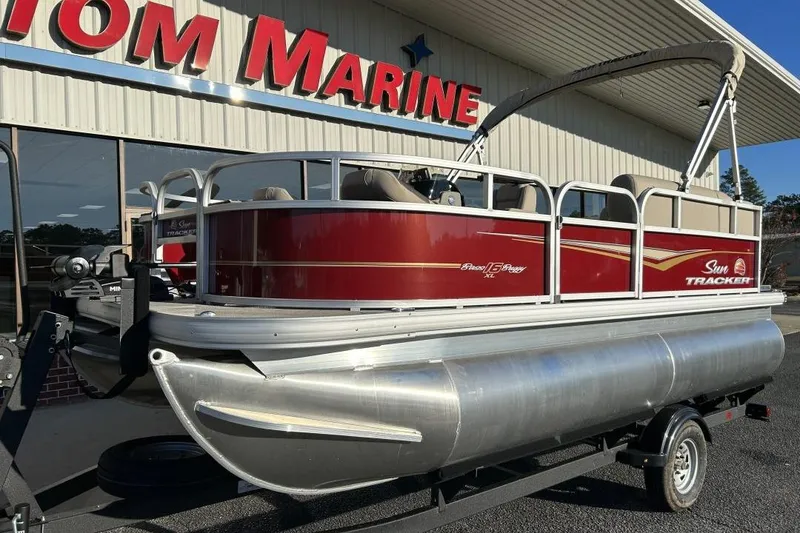 Slide: The Image of 2024 Sun Tracker Bass Buggy 16 XL Select pontoon boat displayed at dealership. - 3
