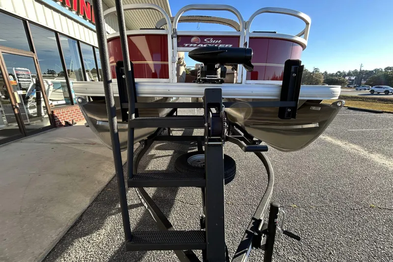 Slide: The Image of 2024 Sun Tracker Bass Buggy 16 XL Select pontoon boat on trailer, parked outside dealership. - 4