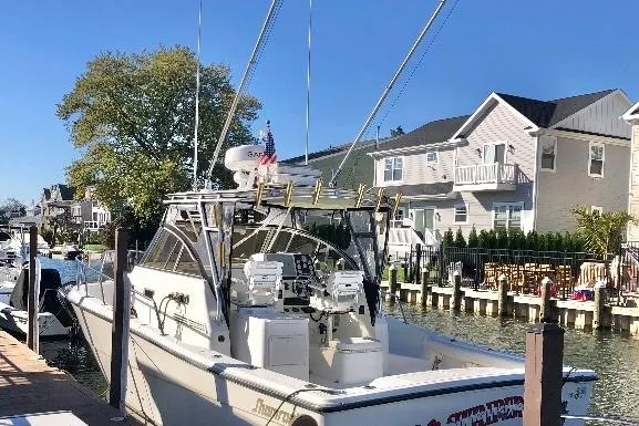 The Image of 2002 Shamrock 290 Walkaround boat docked near waterfront homes. - 0
