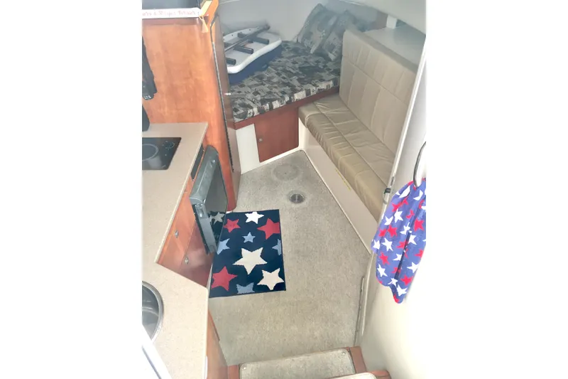 Slide: The Image of Interior of 2002 Shamrock 290 Walkaround boat with seating and star-patterned rug. - 13