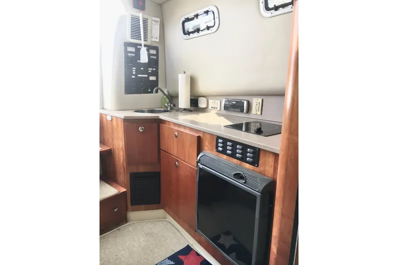 Slide: The Image of 2002 Shamrock 290 Walkaround boat interior with kitchenette, sink, and stove. - 14