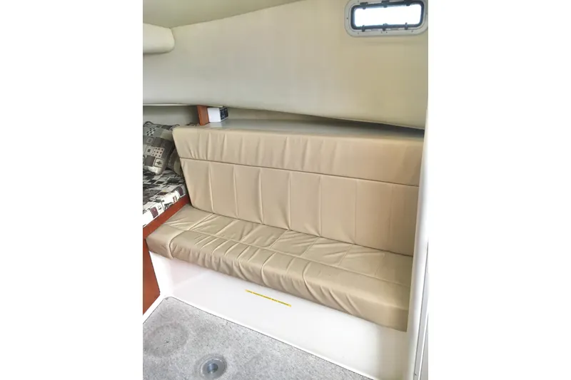 Slide: The Image of 2002 Shamrock 290 Walkaround interior with beige seating and small window. - 15