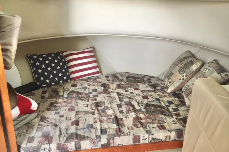 Slide: The Image of Cozy cabin interior of 2002 Shamrock 290 Walkaround with patterned bedding and decorative pillows. - 16