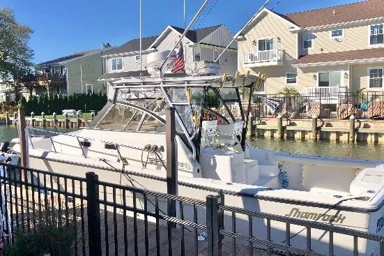 Slide: The Image of 2002 Shamrock 290 Walkaround boat docked near waterfront homes. - 20
