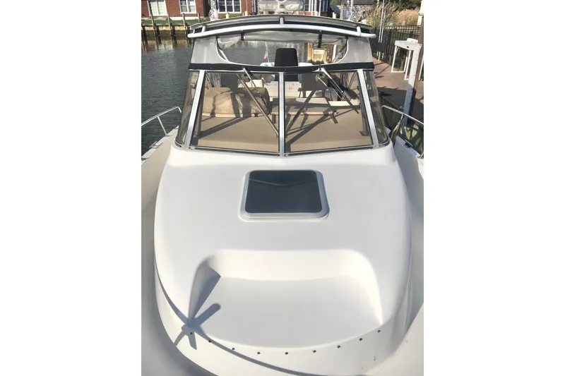 Slide: The Image of 2002 Shamrock 290 Walkaround boat docked, showcasing sleek design and spacious deck. - 5