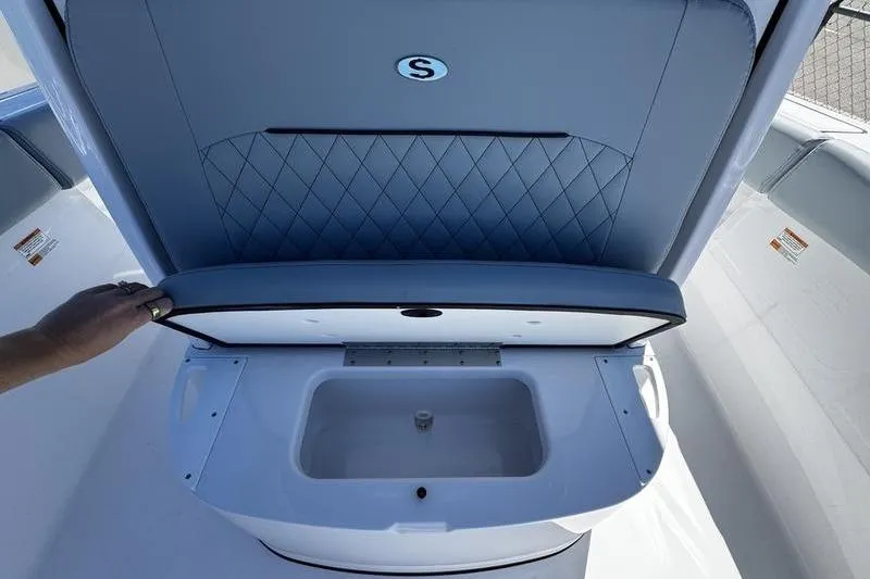 Slide: The Image of 2026 Sportsman Open 232 Center Console boat seat with storage compartment open. - 12