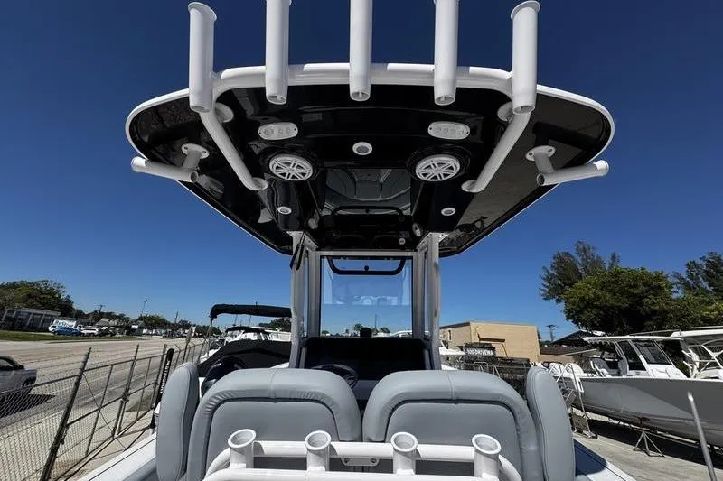 Slide: The Image of 2026 Sportsman Open 232 Center Console boat with T-top and rod holders, viewed from rear. - 20