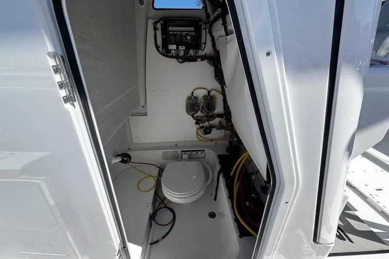 Slide: The Image of 2026 Sportsman Open 232 Center Console interior with marine toilet and wiring. - 23