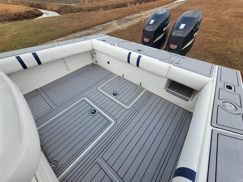 Slide: The Image of 1996 Venture 34 Center Console boat with dual outboard motors, spacious deck, and cushioned seating. - 16