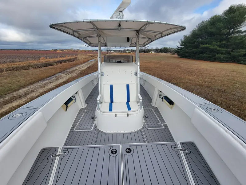 Slide: The Image of 1996 Venture 34 Center Console boat with spacious deck and canopy, set against a scenic landscape. - 20