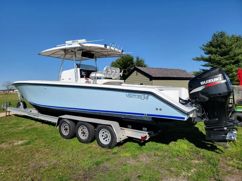 Slide: The Image of 1996 Venture 34 Center Console boat on a trailer with Suzuki outboard motor. - 4