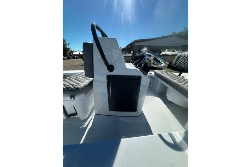 Slide: The Image of 2026 Delta Boatworks Delta D18 interior with steering wheel and seating under bright sunlight. - 12