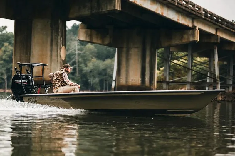 Slide: The Image of 2026 Delta Boatworks Delta D18 on trailer, featuring Suzuki outboard motor, parked outdoors. - 2