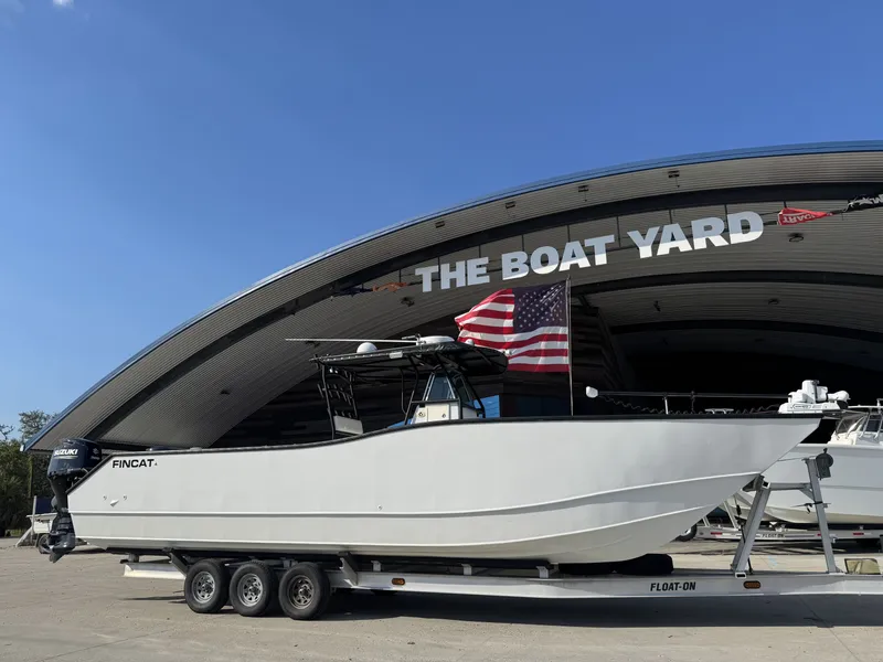 Slide: The Image of 2005 FinCat 35 boat on trailer at The Boat Yard, American flag displayed. - 17