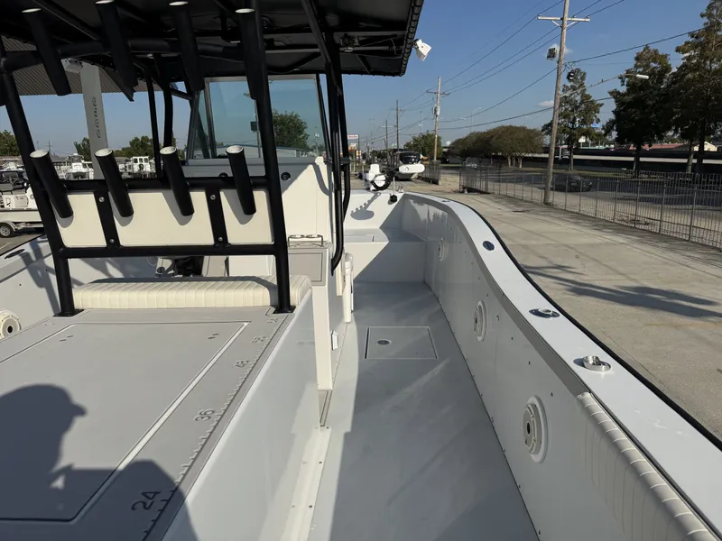 Slide: The Image of 2005 FinCat 35 boat deck with rod holders, spacious seating, and clear sky background. - 20