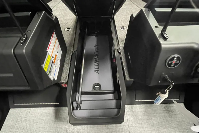 Slide: The Image of 2026 Alumacraft Competitor 185X Sport interior storage compartment with control panel. - 10
