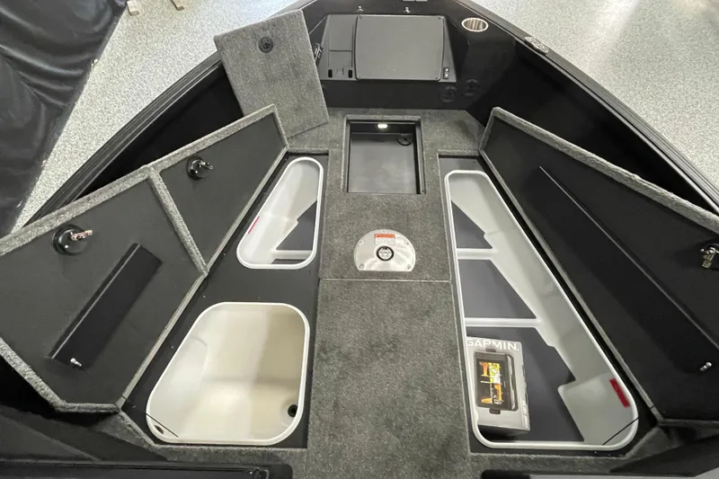 Slide: The Image of 2026 Alumacraft Competitor 185X Sport boat interior with storage compartments and fishing gear. - 11
