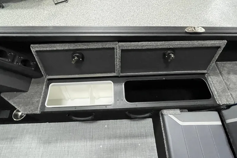 Slide: The Image of 2026 Alumacraft Competitor 185X Sport boat storage compartments with carpeted finish. - 13