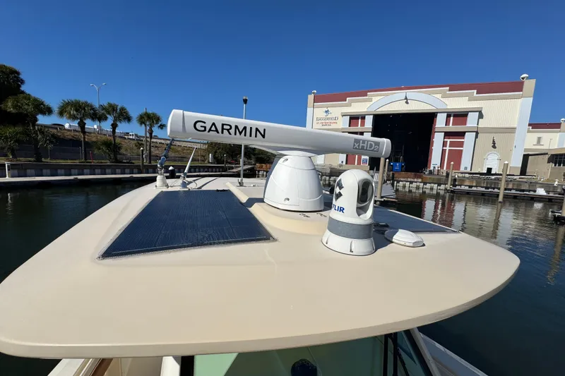 Slide: The Image of 2019 Scout 355 LXF boat with Garmin radar and FLIR camera docked near a marina. - 14