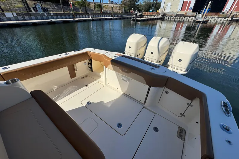 Slide: The Image of 2019 Scout 355 LXF boat interior with triple outboard engines at dock. - 22