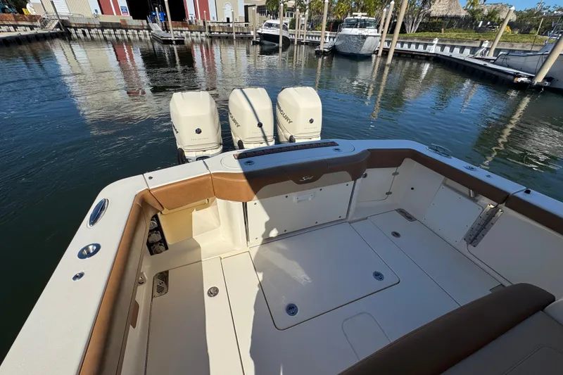 Slide: The Image of 2019 Scout 355 LXF boat with triple engines docked at marina. - 23