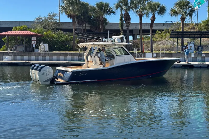 Slide: The Image of 2019 Scout 355 LXF boat docked near palm trees and marina. - 3