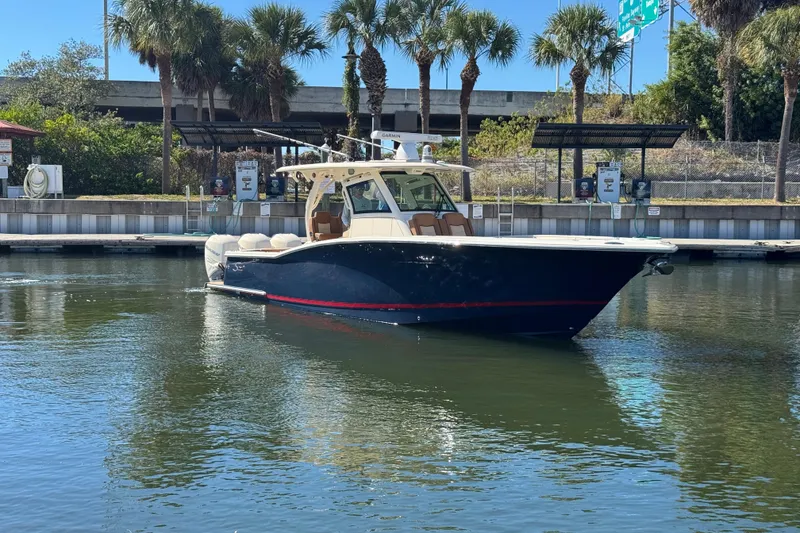 Slide: The Image of 2019 Scout 355 LXF boat docked in a marina with palm trees. - 6