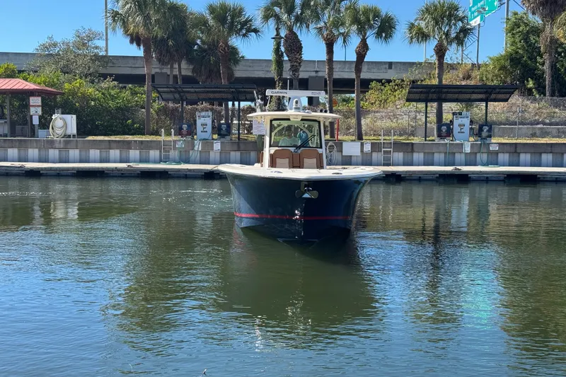 Slide: The Image of 2019 Scout 355 LXF boat docked near palm trees and marina. - 7