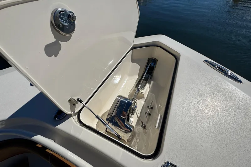 Slide: The Image of Open anchor compartment on 2019 Scout 355 LXF boat, showing polished metal anchor. - 8