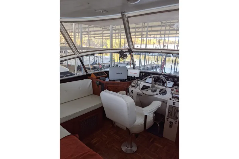 Slide: The Image of 1984 Gulfstar 49 Motor Yacht helm with white seating and navigation equipment. - 14
