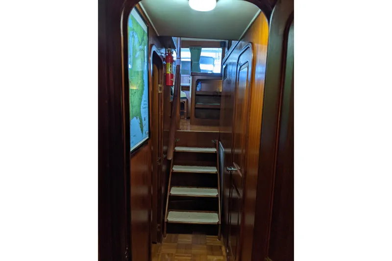 Slide: The Image of Interior of 1984 Gulfstar 49 Motor Yacht with wooden stairs and map on wall. - 24