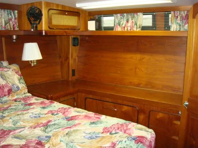 Slide: The Image of 1984 Gulfstar 49 Motor Yacht cabin with wood paneling and floral bedding. - 36