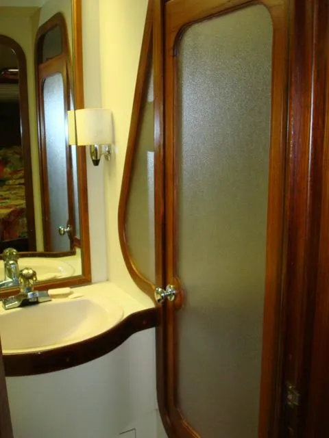 Slide: The Image of 1984 Gulfstar 49 Motor Yacht bathroom with wooden trim and frosted glass door. - 39
