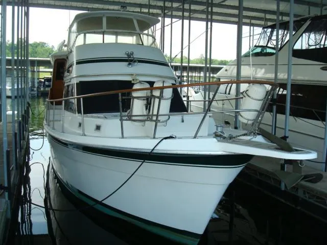 Slide: The Image of 1984 Gulfstar 49 Motor Yacht docked in a marina, showcasing sleek design and classic elegance. - 4