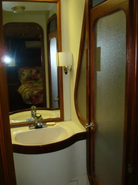 Slide: The Image of 1984 Gulfstar 49 Motor Yacht bathroom with sink, mirror, and wooden accents. - 40
