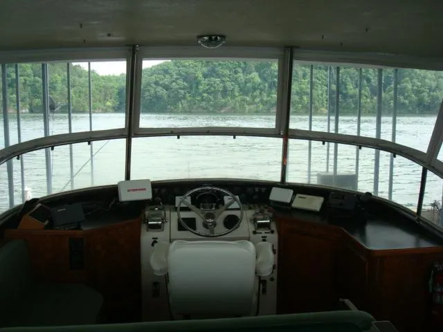 Slide: The Image of 1984 Gulfstar 49 Motor Yacht helm with panoramic water view and lush green shoreline. - 5